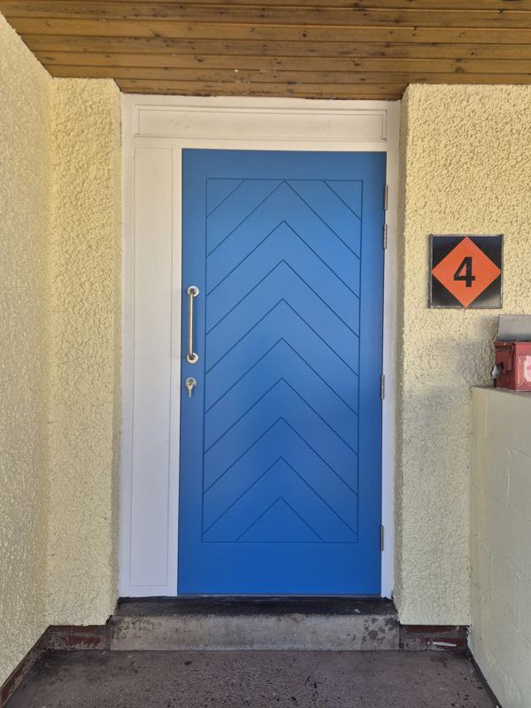 Bespoke blue front door made from Accoya with chevron panel detail, manufactured and spray-finished